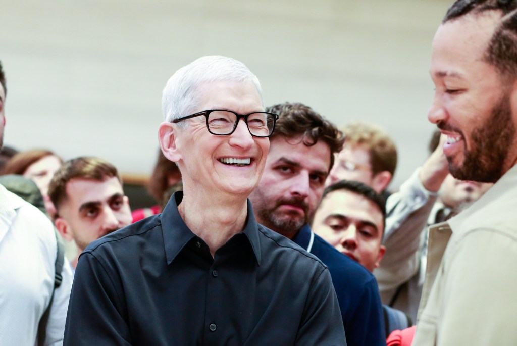 Tim Cook, chief executive officer of Apple Inc., center, and Jalen Brunson, basketball player for the New York Knicks, right, during the first day of in-store sales of Apple's latest products at Apple's Fifth Avenue store in New York, US, on Friday, Sept. 19, 2025. The new iPhone 17 is seen as the most significant upgrade Apple has brought to its iPhone lineup in years, with a refreshed design and souped-up camera system. Photographer: Kena Betancur/Bloomberg