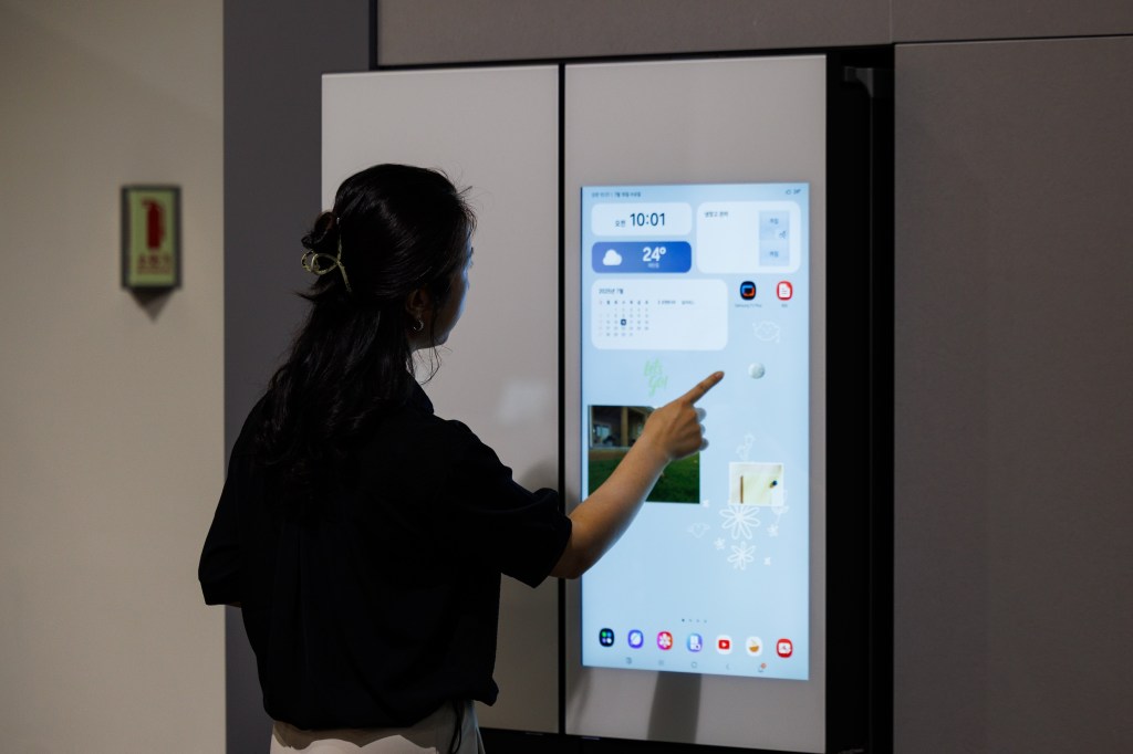An employee demonstrates an AI refrigerator inside the Samsung Electronics Co. Innovation Museum at the company's headquarters in Suwon, South Korea, on Wednesday, July 16, 2025. Samsung is in talks with the likes of OpenAI Inc. and Perplexity AI Inc. to integrate more AI services in upcoming Galaxy devices, seeking a wider range of offerings beyond Google’s Gemini. Photographer: SeongJoon Cho/Bloomberg